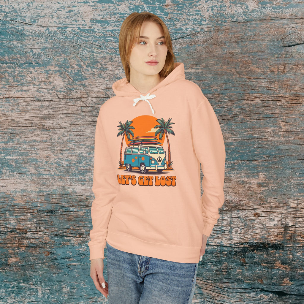 Person wearing a peach hoodie with a graphic design against a wooden background