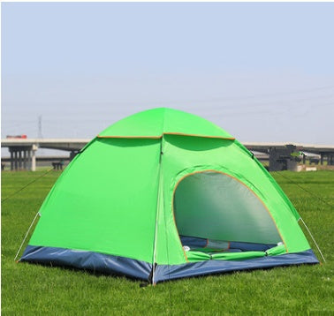 Green camping tent on grass with a clear sky background