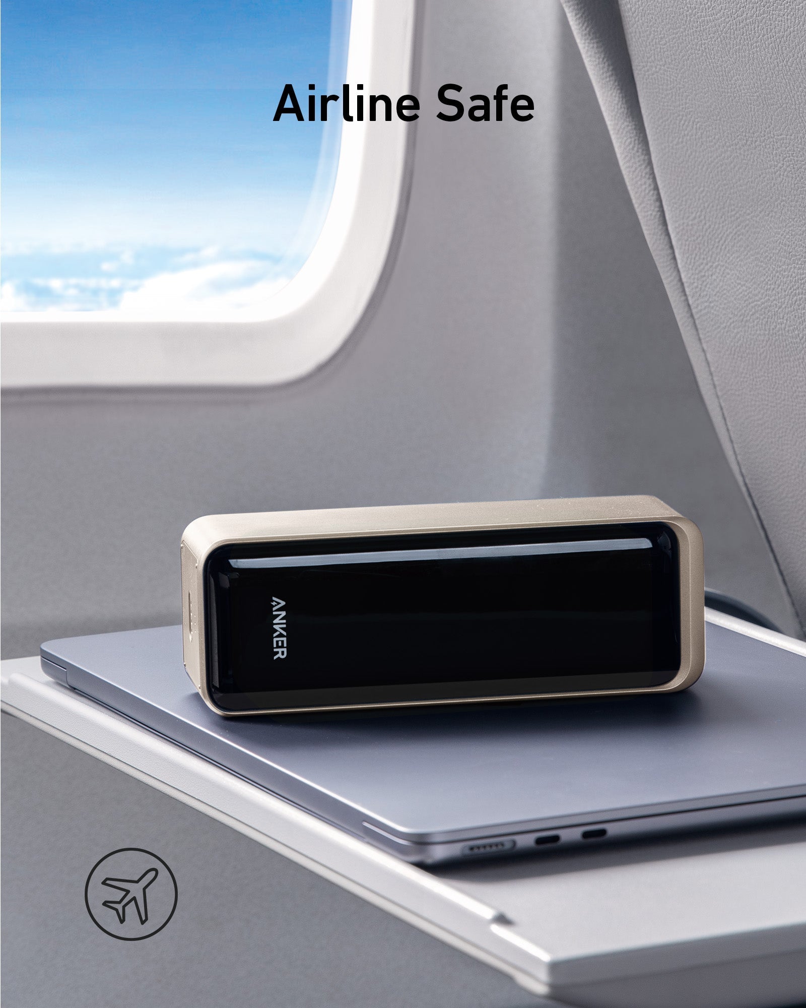 Anker power bank on a tray table with airplane window in the background