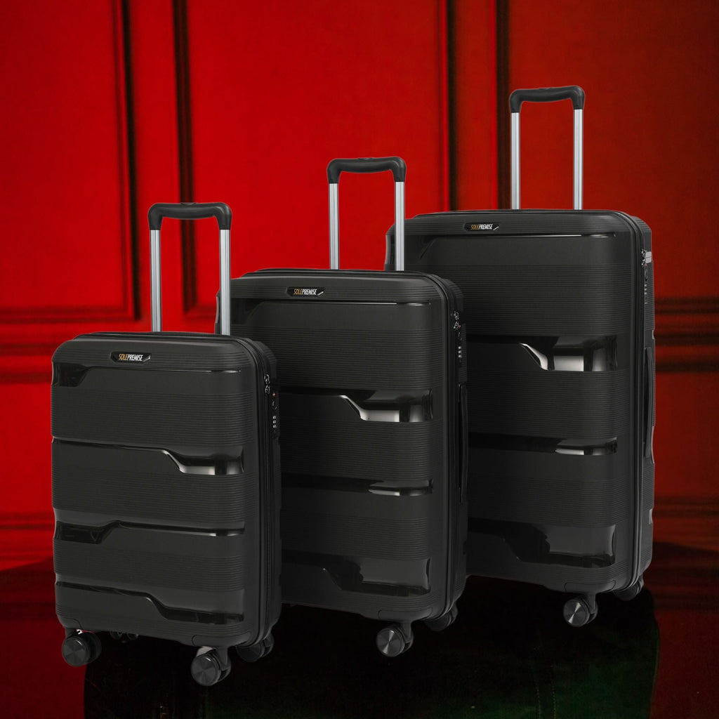Three black suitcases of different sizes on a red background