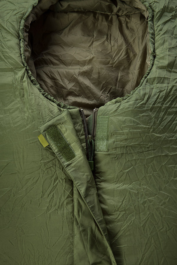 Close-up of a green textured jacket with a zipper and patch.