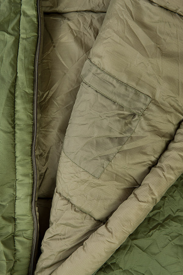 Close-up of a green quilted fabric with a zipper