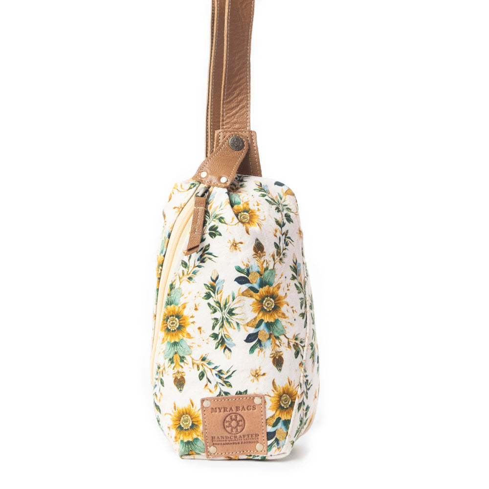 Floral-patterned bag with a brown strap on a white background