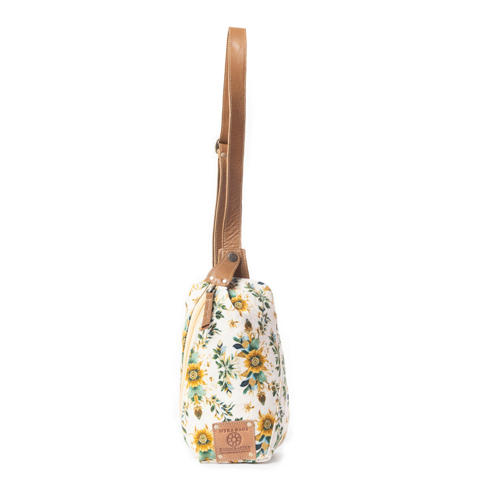 Floral-patterned crossbody bag with a brown strap on a white background
