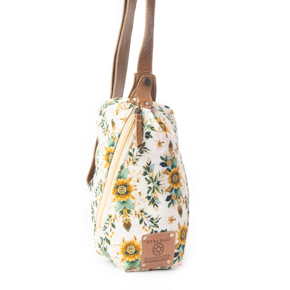 Floral patterned bag with a brown strap on a white background