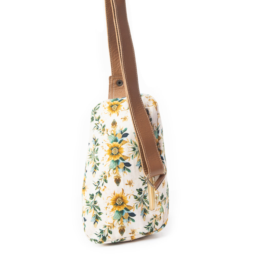 Floral-patterned bag with a brown strap on a white background