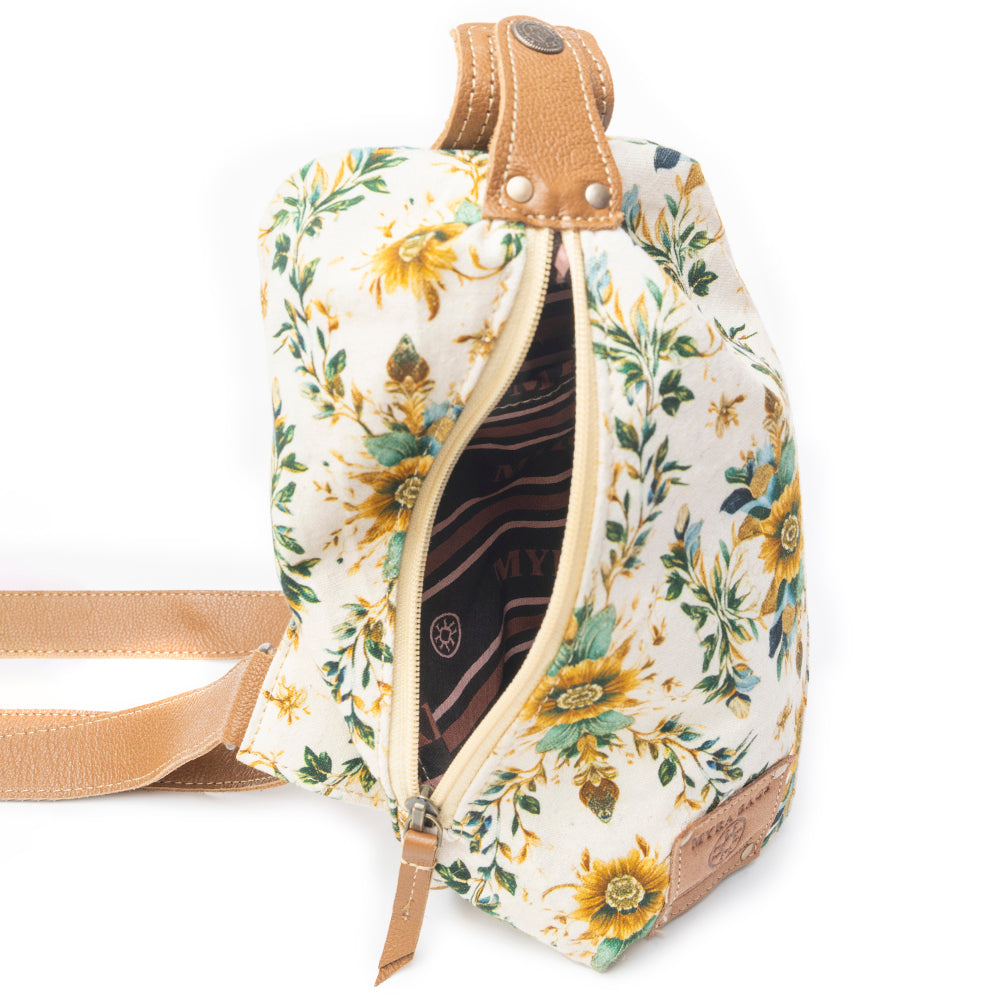 Floral-patterned bag with a tan strap on a white background