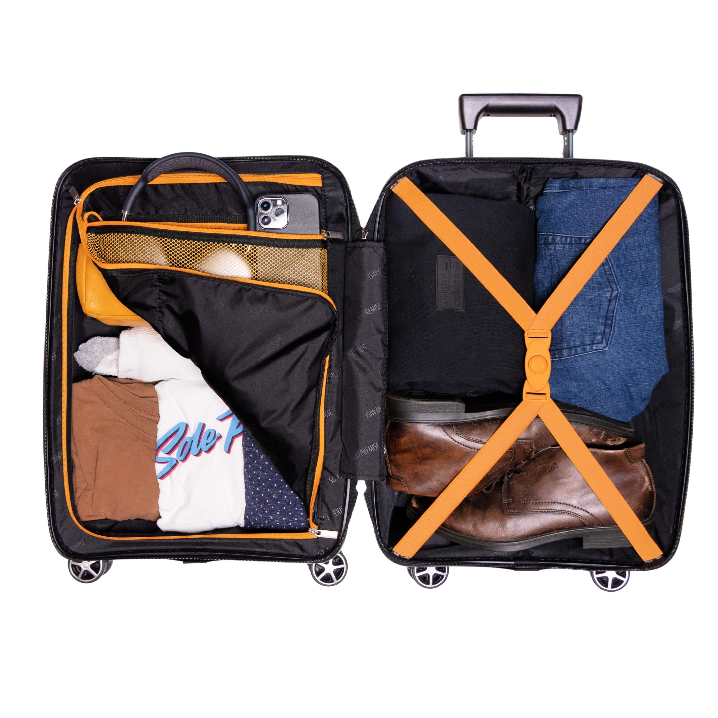Open suitcase with clothes and items inside on a white background
