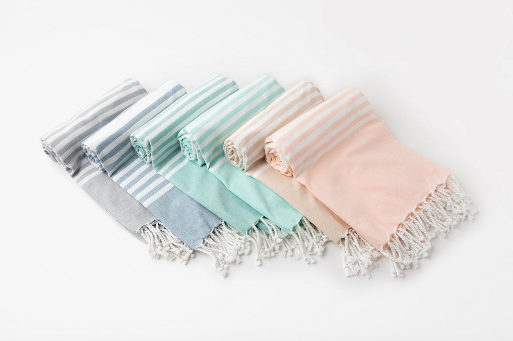 Set of pastel-colored scarves with tassels on a white background