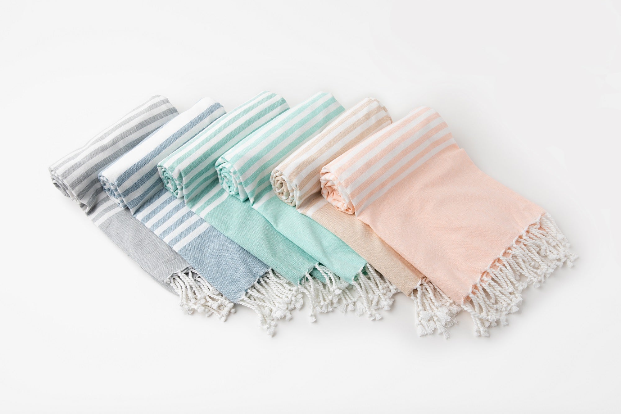 Set of pastel-colored scarves with tassels on a white background