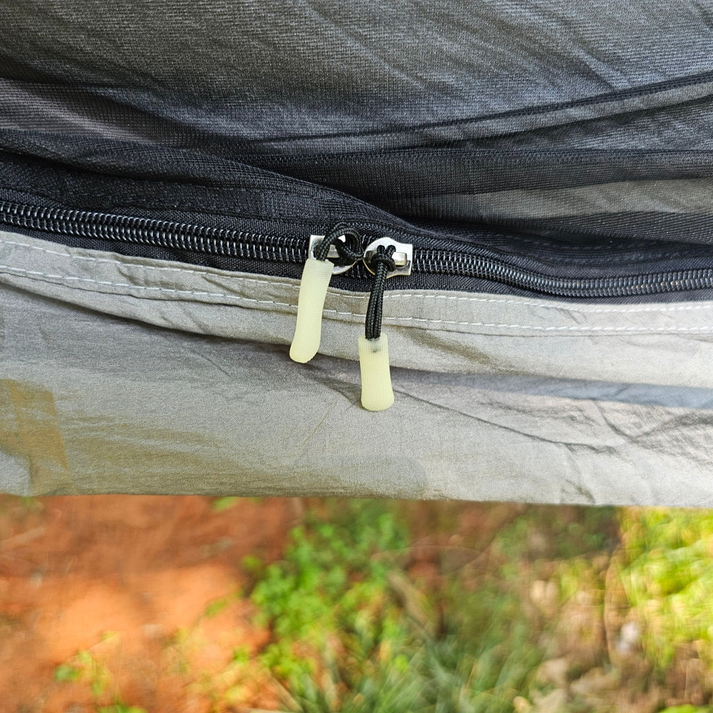 Close-up of a zipper on a fabric surface with a blurred natural background