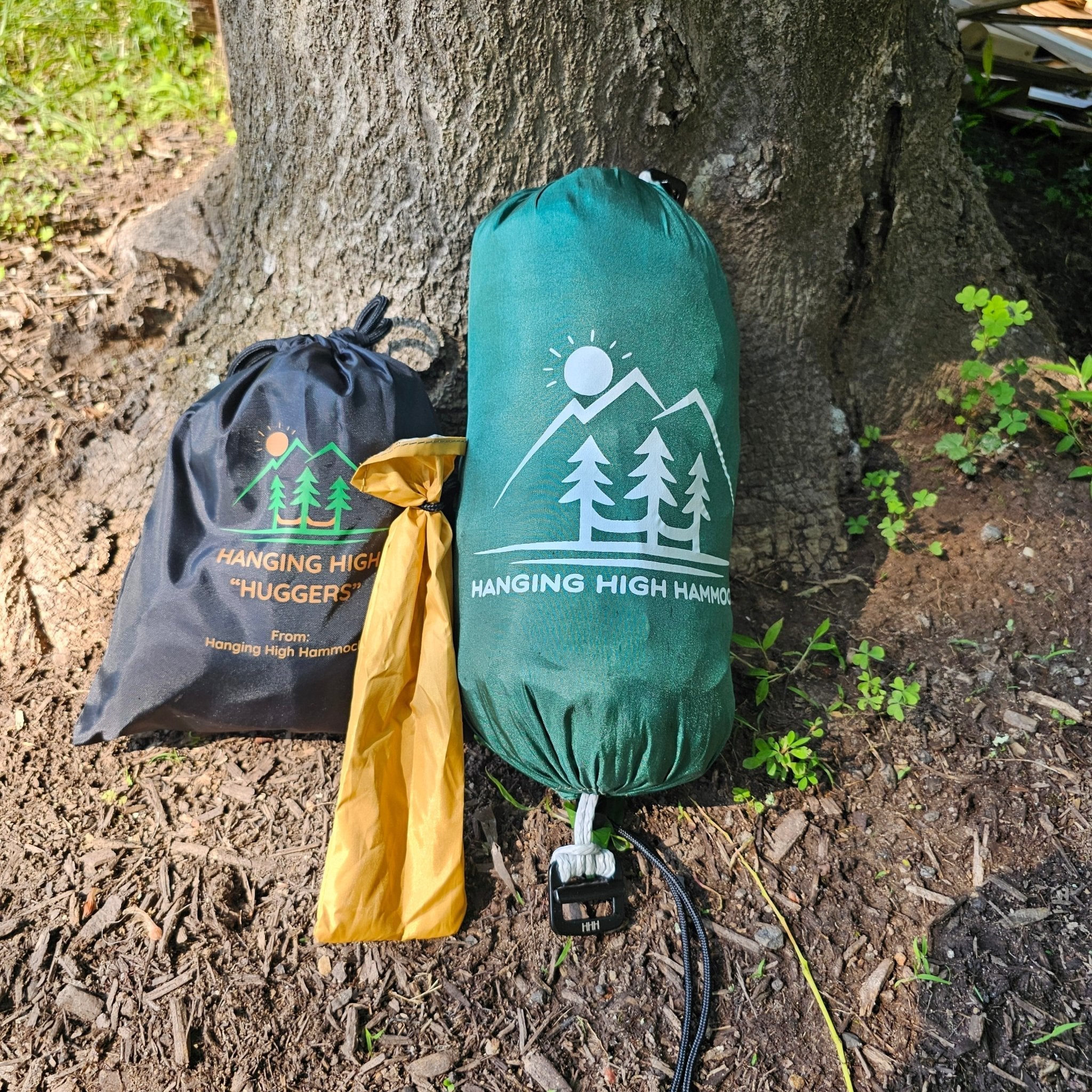 Hanging high hammock packaging with tree hugger and green hammock against a tree