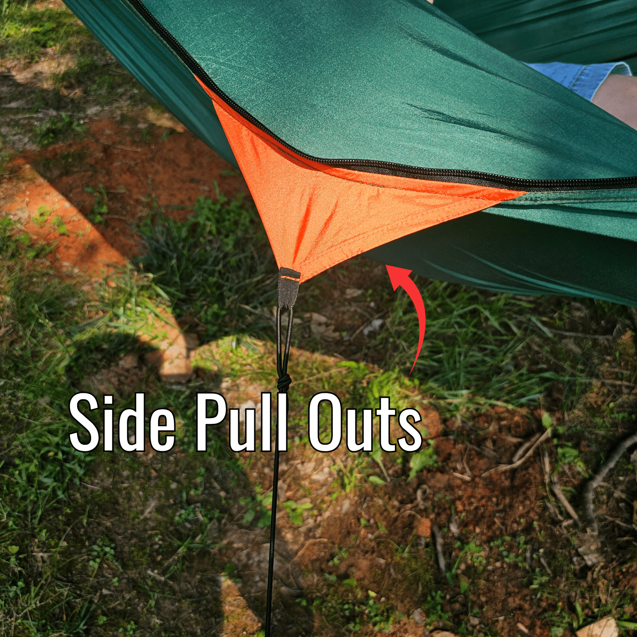 Green and orange camping hammock with side pull-out feature on grassy ground