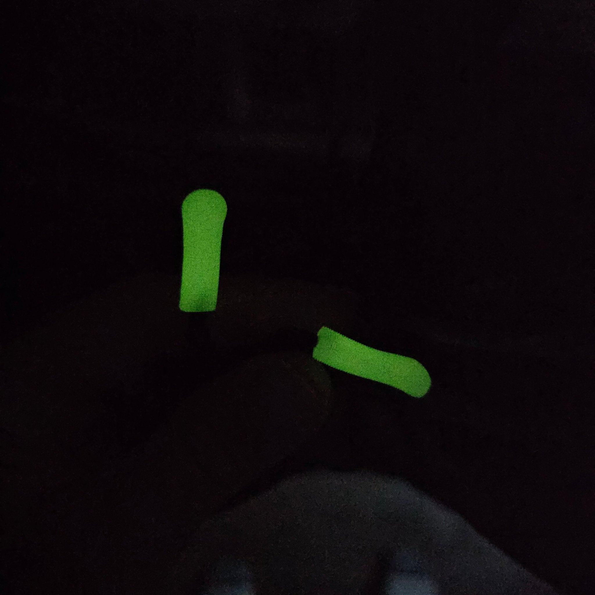 Two green objects on a black background