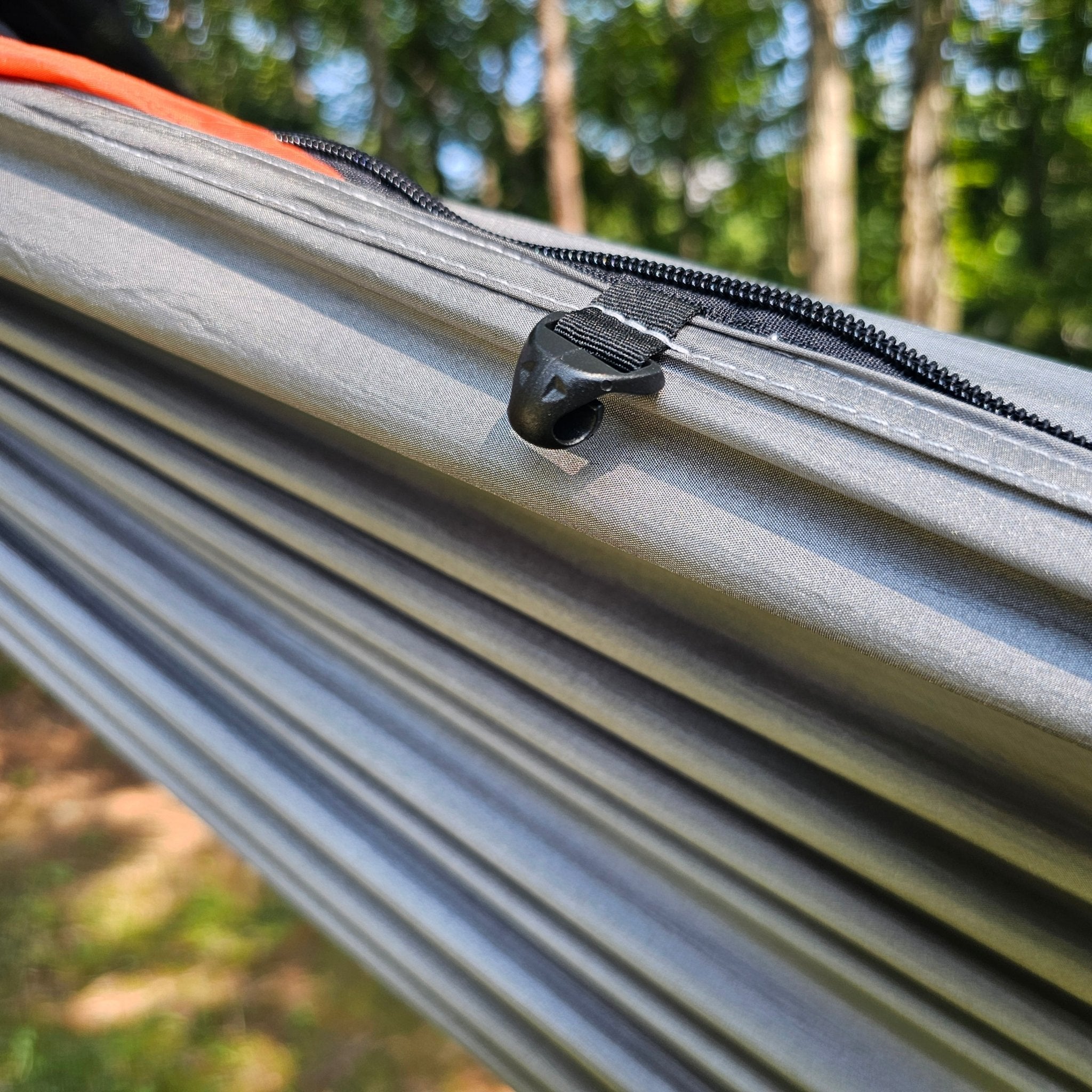 Close-up of a hammock with a zipper in a forest setting