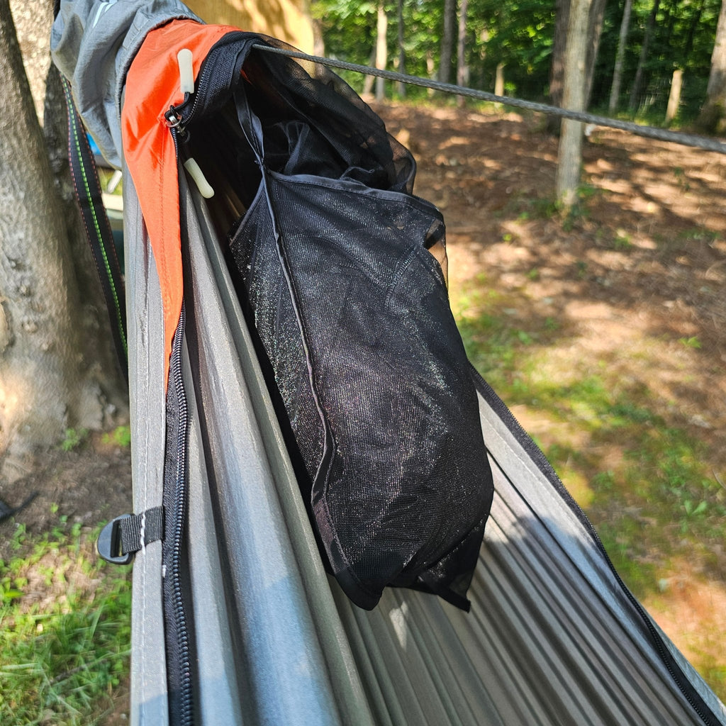 Close-up of a black bag inside a hammock with a forest background