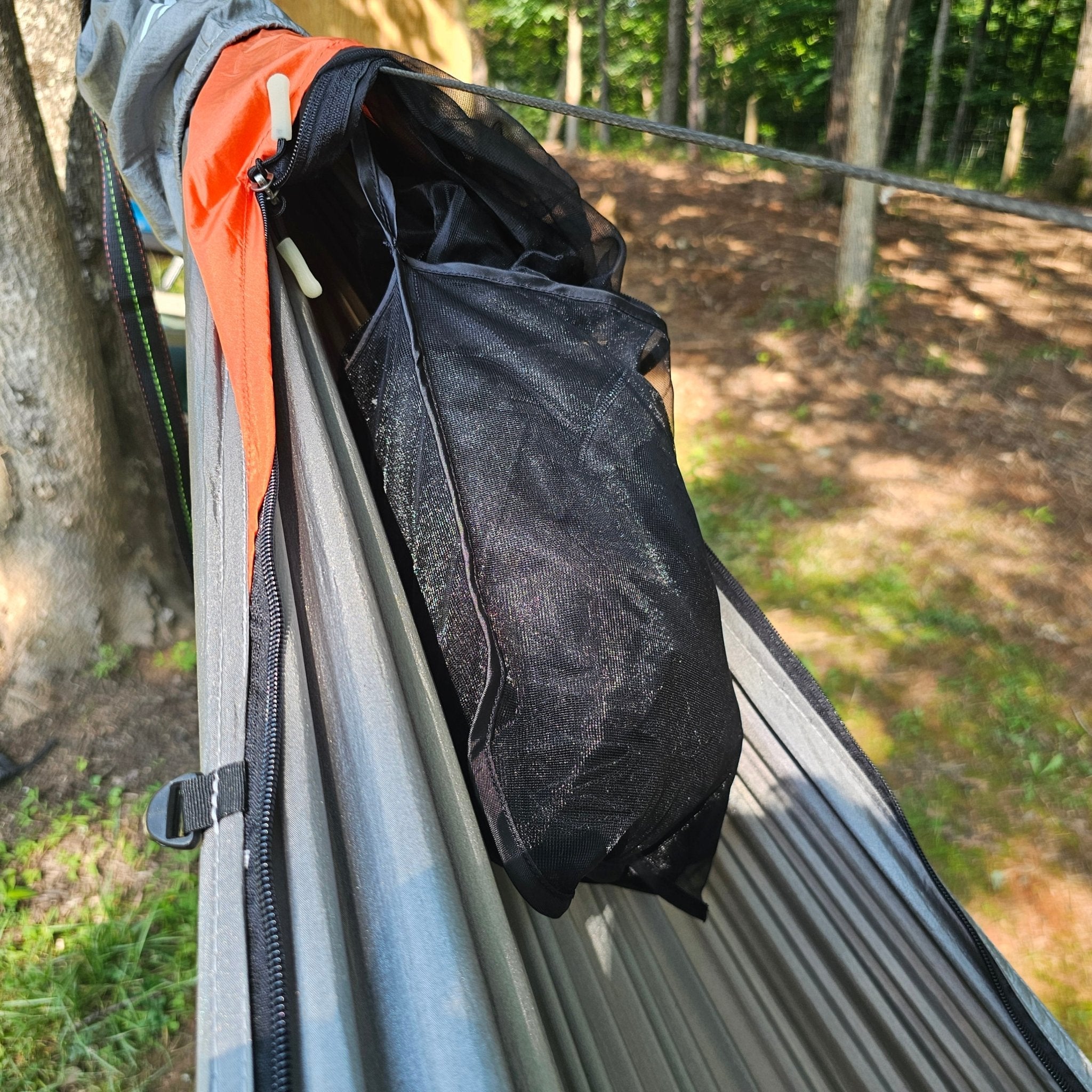 Close-up of a black bag inside a hammock with a forest background