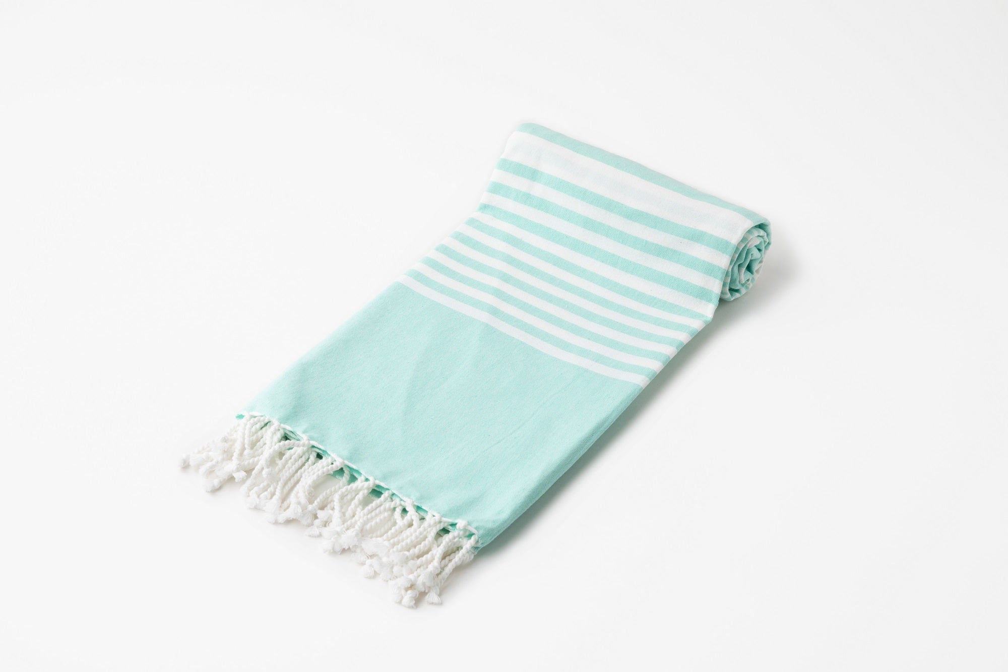 Turquoise towel with white stripes and fringes on a light gray background